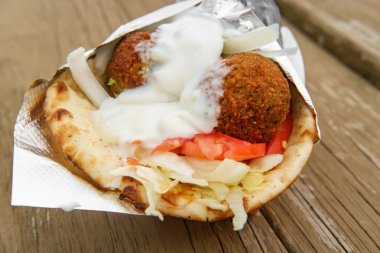 Taze ve sağlıklı falafel, Tzatziki domates, kırmızı soğan ve pide ekmekli buzdağı marulu.