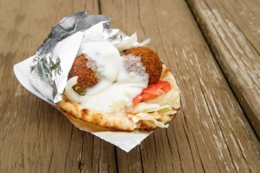 Taze ve sağlıklı falafel, Tzatziki domates, kırmızı soğan ve pide ekmekli buzdağı marulu.