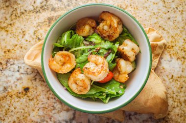 Bahar karides salatasıyla mermer mutfak masasını karıştırın.