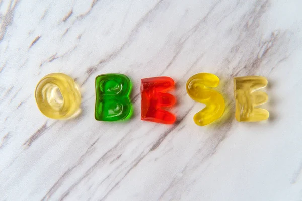 Assorted Colorful Gummy Candy Letters Spell Word Obese — Stock Photo, Image