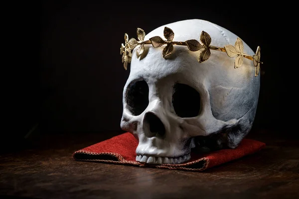 Human skeleton skull of King or Queen wearing royal gold leaf crown
