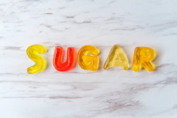 Verschiedene Bunte Gummibärchen Buchstaben Buchstabieren Das Wort Zucker — Stockfoto