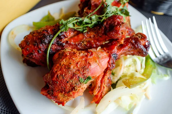 Indian cuisine spicy Tandoori chicken with cilantro garnish