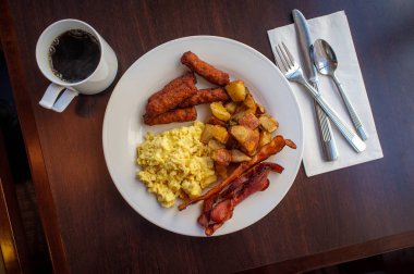Sahanda yumurta kahvaltı sosis ev patates ve domuz pastırması ile