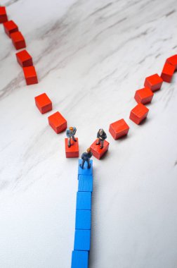 Minyatür işadamları iki farklı ahşap blok yolu birinin üzerine ikna