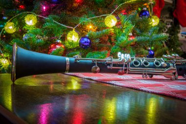 Seasonal holiday musical instrument clarinet with Christmas tree background clipart
