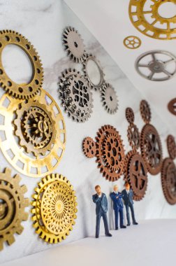 Yenilikçi kavramsal metafor için dişliler ve dişlilerle çevrili iş adamları.