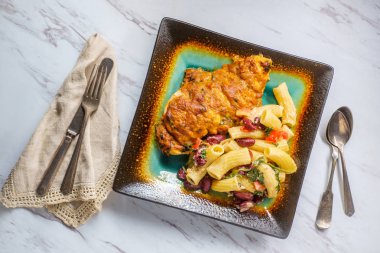 Güneşte kurutulmuş domates kırmızı pesto mozzarella peyniri ve sarımsak parmesan Roma rigatoni rigati bir tarafı ile Yunan hasselback tavuk 