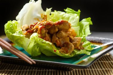 Kore baharatlı tavuk marul şal bambu hasır üzerinde hizmet gochujang sos ile