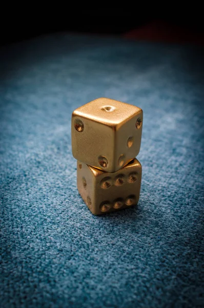 Lucky golden gambling dice on blue green billiards table