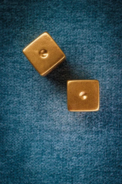 Lucky golden gambling dice on blue green billiards table