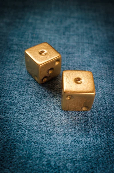 Lucky golden gambling dice on blue green billiards table