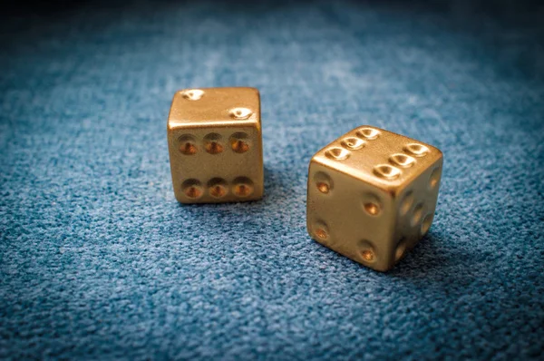 Lucky golden gambling dice on blue green billiards table