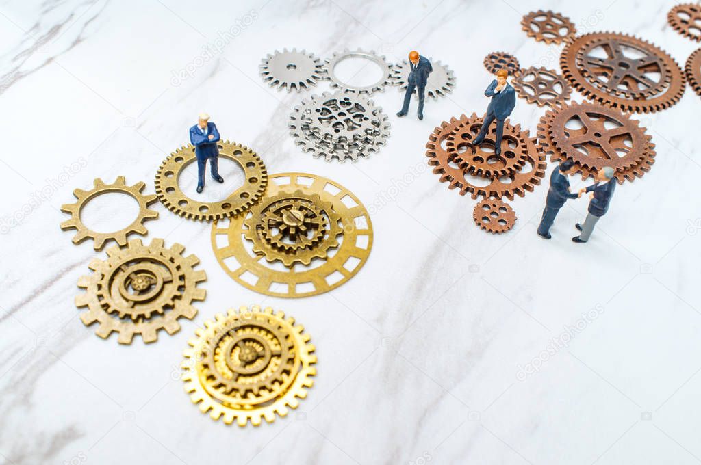Businessmen surrounded by gears and cogs for innovation conceptual metaphor