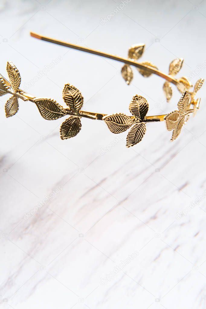 Golden laurel leaf Greek or Roman crown on marble table