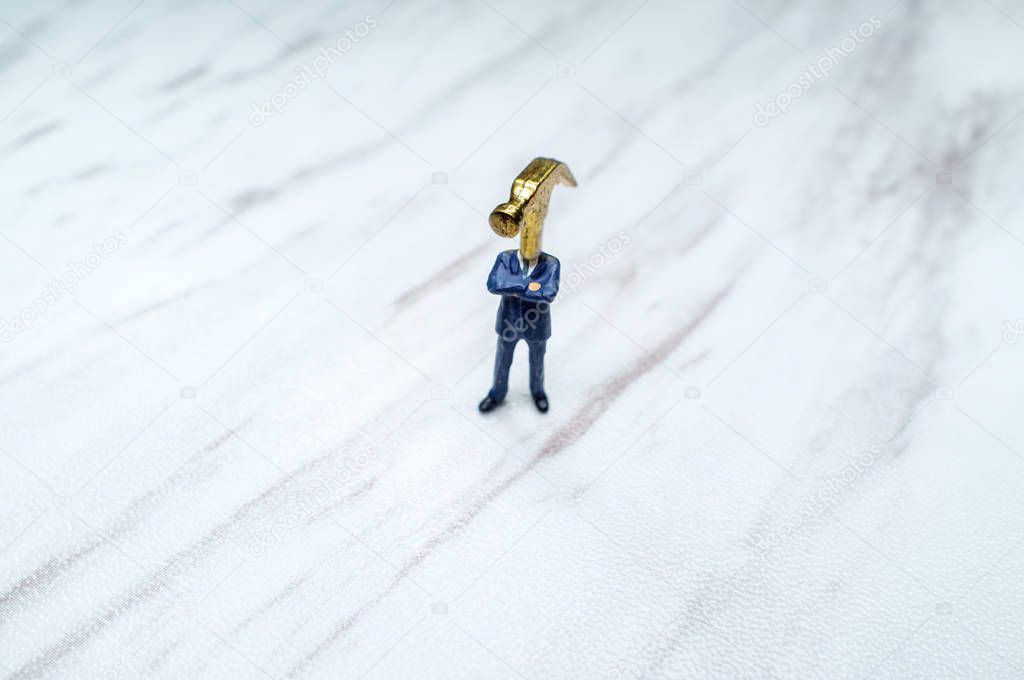 Miniature figure businessman with hammer for a head concept