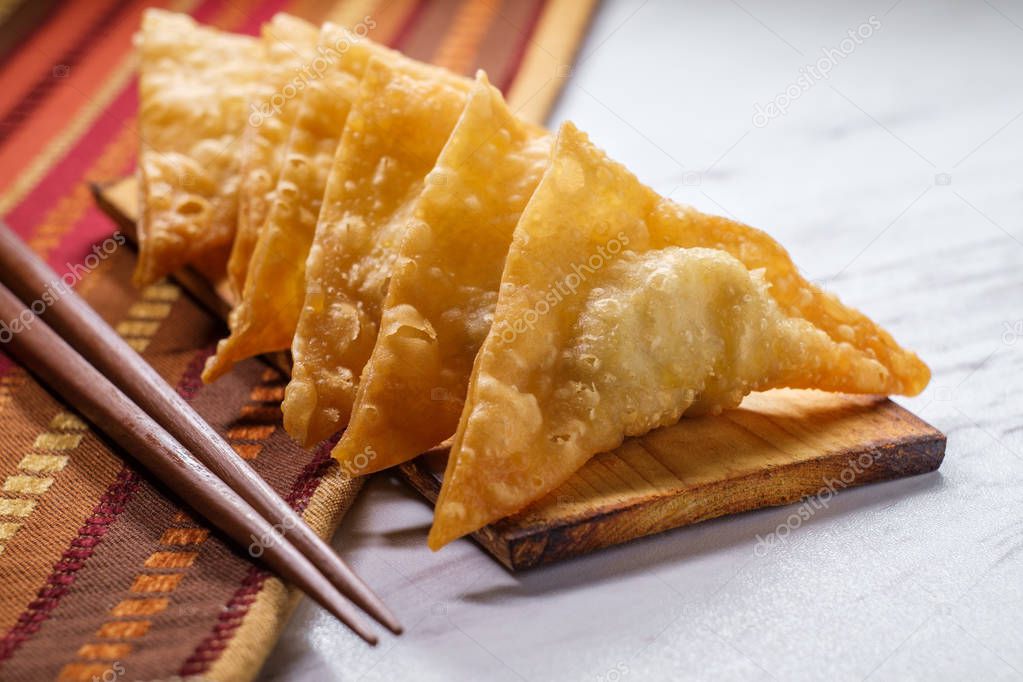 Authentic crispy Korean deep-fried mandu dumplings on wooden plate