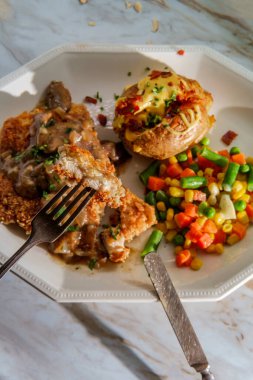 Alman bademi tavuk jagerschnitzel yanında fırında patates ve sebze.