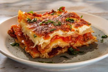 Ev yapımı İtalyan peyniri ve mermer mutfak masasında etli lazanya.