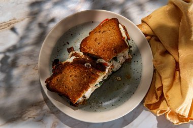 Kızarmış tavuk mozzarella ve domatesli lahana peynirli sandviç.