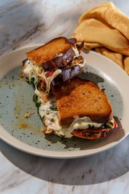 Kızarmış tavuk mozzarella ve domatesli lahana peynirli sandviç.