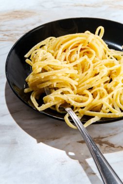 Otantik sade İtalyan fettuccine alfredo akşam yemeği mermer masada.