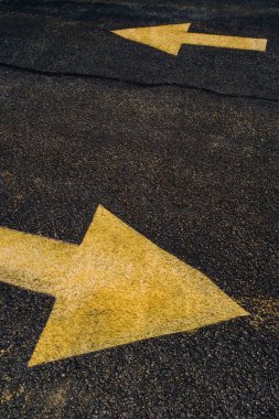 Yol veya otoparkta trafik şablonlarını yönetmek için sarı oklar boyanmış