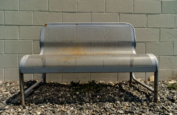 Worn metal bench with brick wall background with nobody