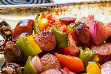 Polonya usulü ızgara bal ballı balzamik sosis şiş kebap şiş şiş şiş kırmızı soğan mantar biber ve domates.