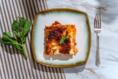 Ev yapımı İtalyan peyniri ve mermer mutfak masasında etli lazanya.