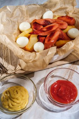 Peru fast-food salchipapas patates kızartması ve haşlanmış bıldırcın yumurtalı dilimlenmiş sosis.
