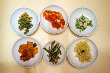 Kimchi ve mung fasülyesi dahil altı Kore banchan mezesi.