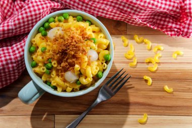 Macaroni and cheese with green peas and pearl onions garnished with toasted breadcrumbs clipart