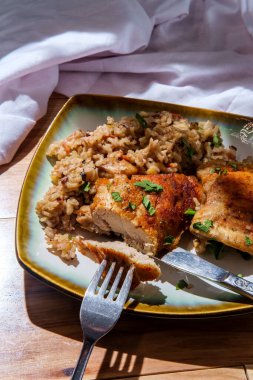 İtalyan sarımsaklı kemiksiz ve derisi yüzülmemiş tavuk butları ve kremalı kahverengi pirinç, mantarlı yeşil bezelye ve doğranmış havuç.