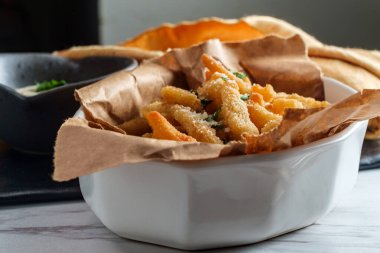 Bir kase tartar sosuyla servis edilen New England kızarmış midye şeritleri.