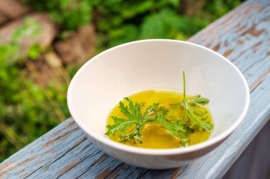 Ev yapımı sivrisinek kovucu yapmak için yağın içinde dinlenen bir sitronella yaprağı.