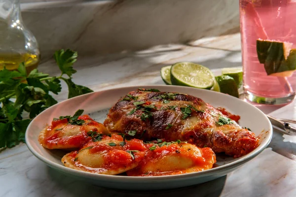 Italian chicken parmigiana dinner with ravioli and pink limeade