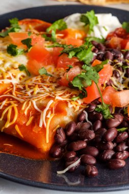 Otantik Meksika chimichanga burrito ile ekşi kremalı pirinç ve siyah fasulye.