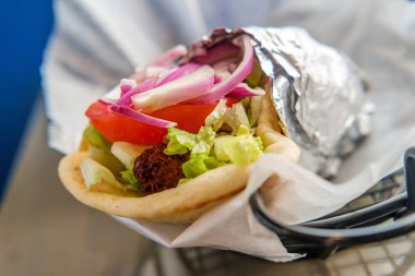 Taze ve sağlıklı falafel, Tzatziki domates, kırmızı soğan ve pide ekmekli buzdağı marulu.