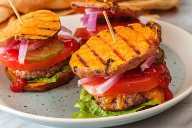 Glütensiz tatlı patates ekmeği ızgara çizburger dilimleri.