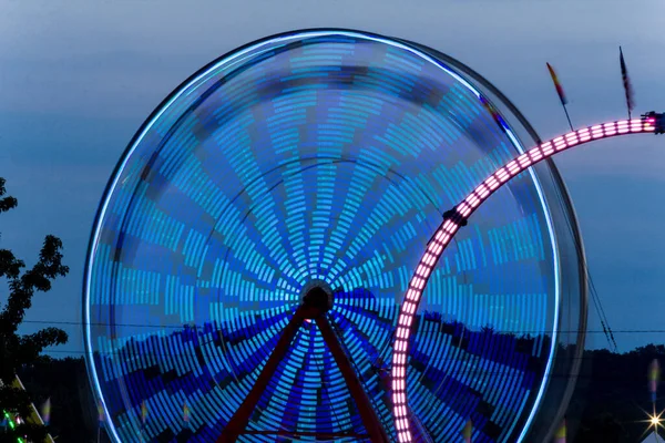 Summer carnival ferris wheel at night with light blur time lapse