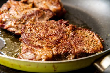 Tavada kızarmış biftek ve cızırdayan zeytinyağı.