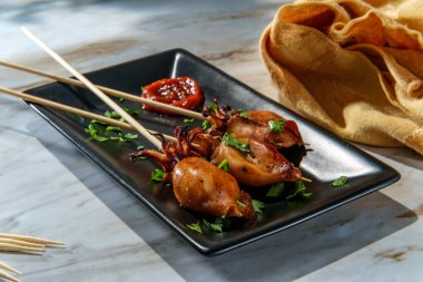 Deniz ürünleri ızgara kalamar satay kebap, dokunaçlı şiş ve acı sos.