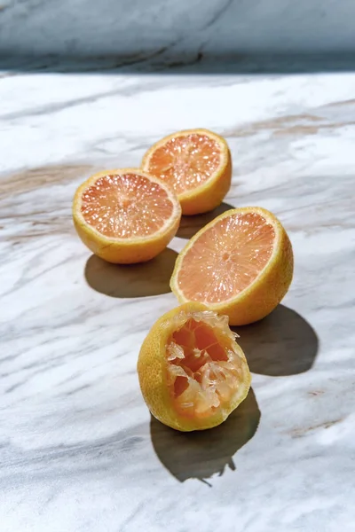 Mermer Mutfak Masasında Dilimlenmiş Sıkılmış Pembe Etli Eureka Limonları — Stok fotoğraf