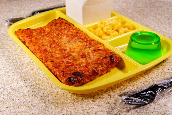 小箱入りの牛乳パック入りのピザとデザート用の緑のゼラチン付きの学校給食トレイ — ストック写真