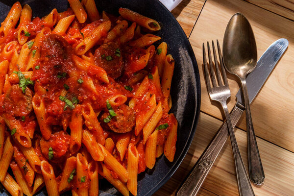 Italian penne pasta in spicy arrabbiata tomato sauce with Italian sausage