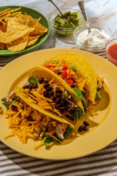 Mexican chicken tacos with rice tortilla chips and various toppings