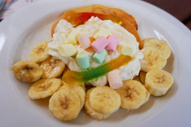 Lezzetli, güzel, dekore edilmiş krep domuz pastırmalı, beyaz, çikolatalı, altın akçaağaç şurubu soslu domuz pastırmalı, beyaz tabakta sağlıklı kahvaltı. 