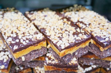 Çikolatalı, portakallı, mangolu, kurabiyeli ve kremalı turunçgil aromalı karamel dilimleri Yeni Zelanda 'nın ünlü tatlı tatlısı pirinç gevreği, çıtır çıtır ve sağlıksız yemekler. 