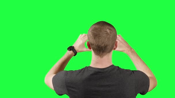 Mladý muž střílí video pomocí telefonu Smartphone na zeleném pozadí obrazovky — Stock video